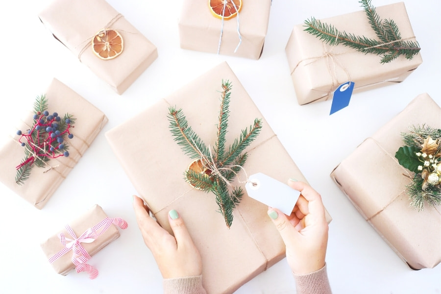 a woman putting a gift tag on a present