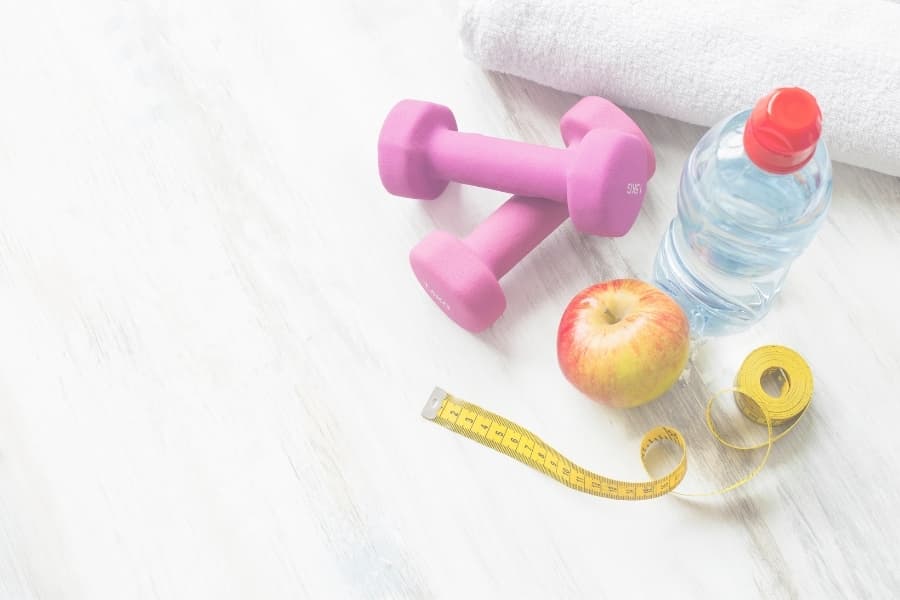 Weights, apple, water bottle, and measuring tap on the floor