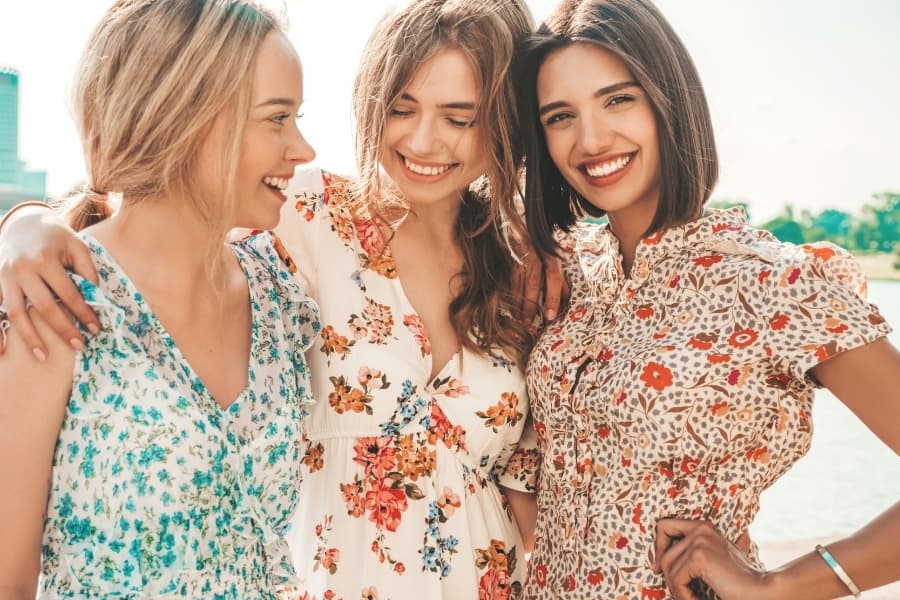 Three woman in floral dressing hanging out together before their sorority chapter meeting.