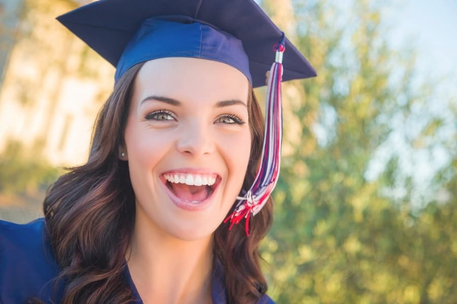 A young woman smiling on the day of her college graduation.